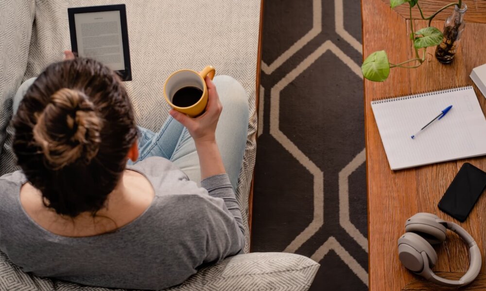 Woman reads e-book while drinking coffee