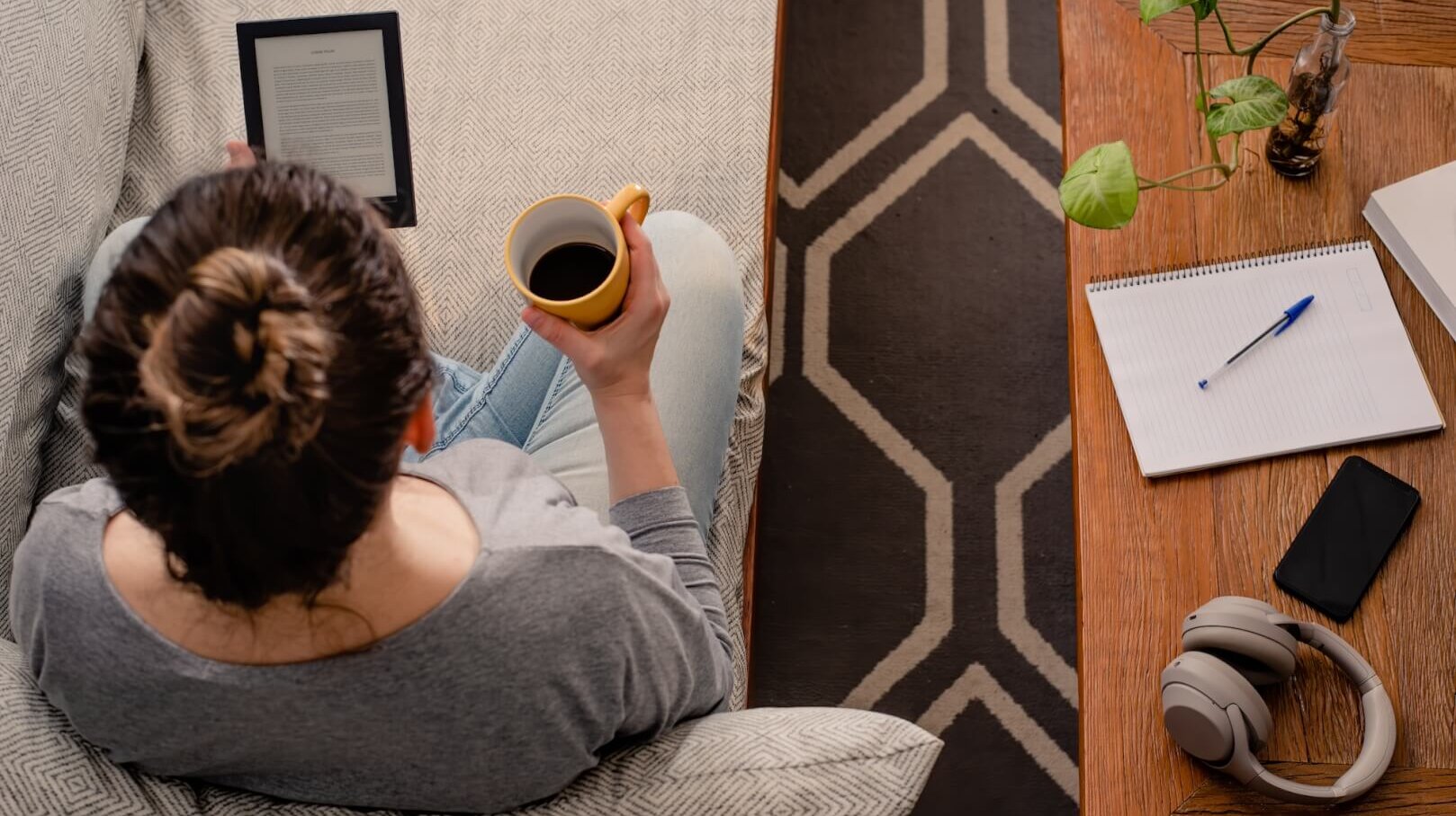 Woman reads e-book while drinking coffee