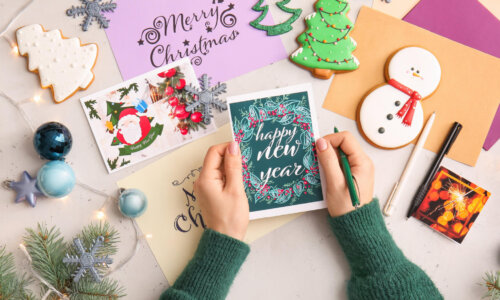 Woman holds holiday card over decorated table