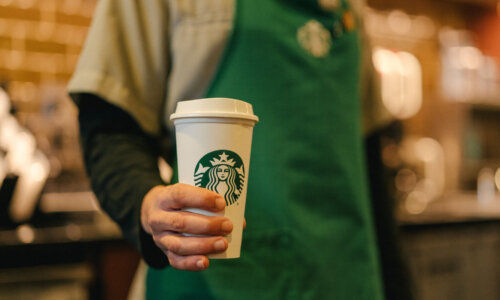 Starbucks barista holding to-go cup