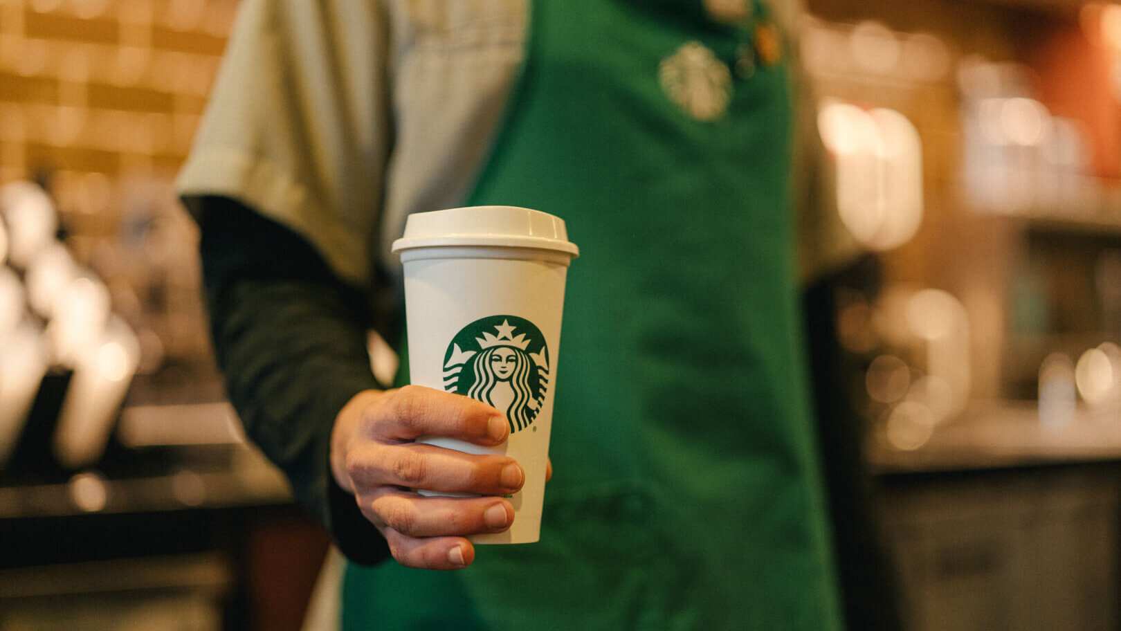 Starbucks barista holding to-go cup