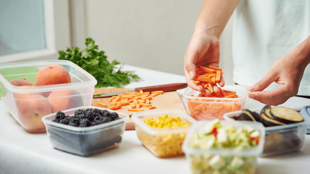Woman putting chopped food into plastic storage containers