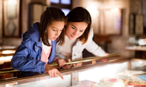 Daughter points into display case at museum