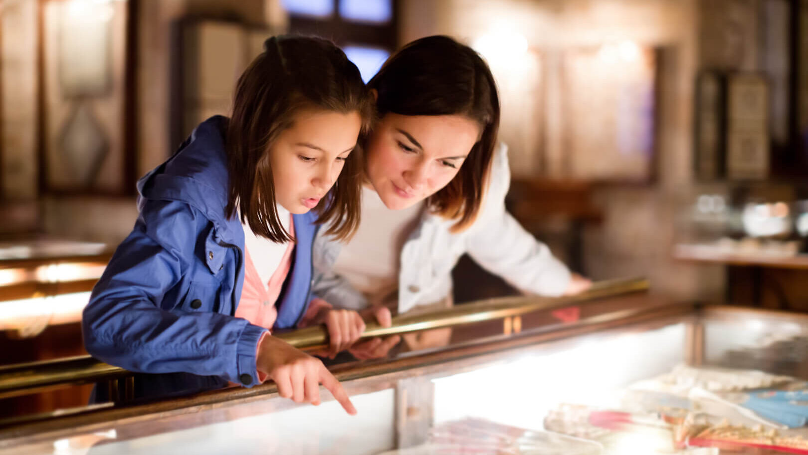Daughter points into display case at museum