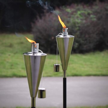silver tiki torches with burning flames outside