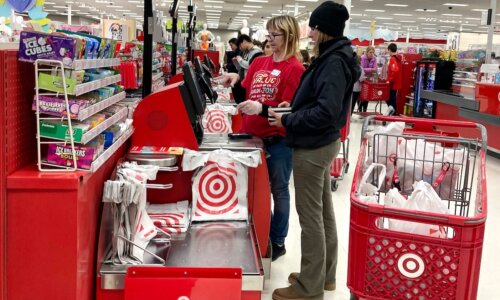 Worker helps customer at Target self-checkout
