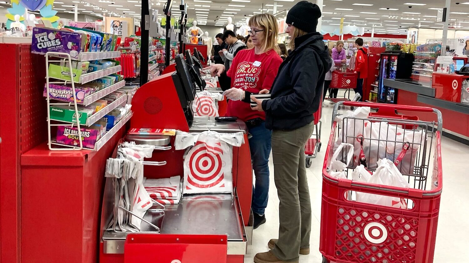 Worker helps customer at Target self-checkout