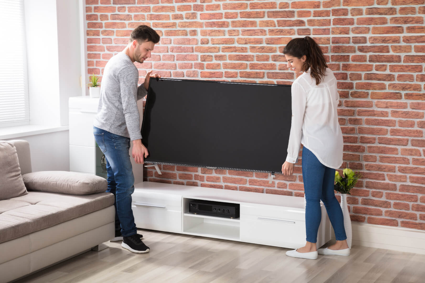 Couple moves television in living room