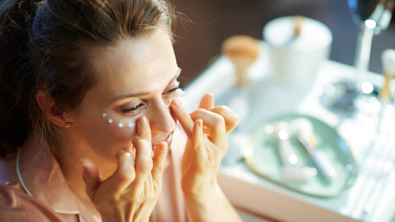 woman putting on eye cream